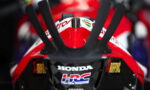 Front view of a red Honda racing motorcycle, featuring the HRC logo on the nose and racing decals.