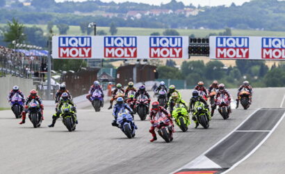 Group of motorcycle racers start a race on a track, banners reading LIQUI MOLY above them.