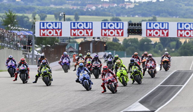Group of motorcycle racers start a race on a track, banners reading LIQUI MOLY above them.