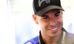 Smiling man wearing a black cap and Yamaha lanyard, close-up portrait.