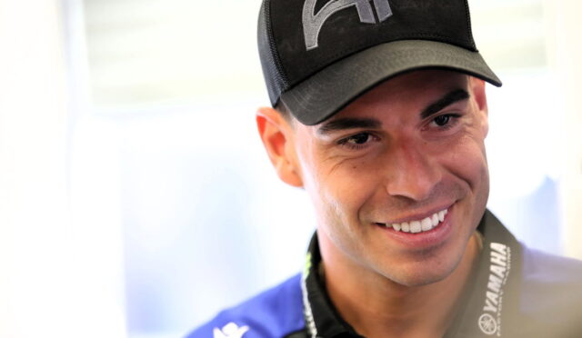 Smiling man wearing a black cap and Yamaha lanyard, close-up portrait.