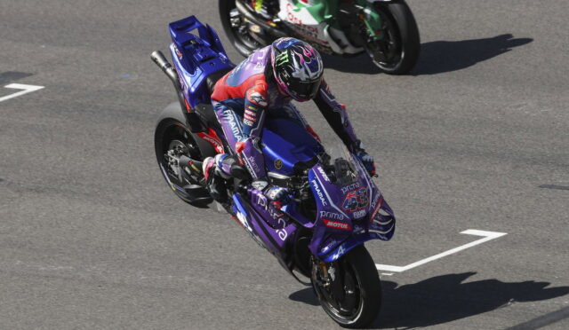 Racer on a purple Yamaha sport motorcycle leaning through a corner on a racetrack, number 43 visible on the bike.
