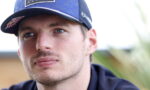 Close-up portrait of a man wearing a blue Oracle Red Bull Racing cap, looking off to the side.