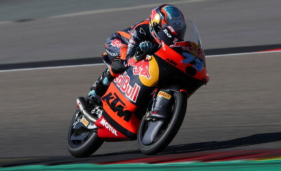 MotoGP rider on a Red Bull KTM racing bike, leaning into a turn on the track