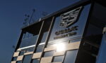 Cadillac Formula Team glass-walled building with the logo reflected and a sun glare.
