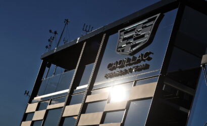Cadillac Formula Team glass-walled building with the logo reflected and a sun glare.