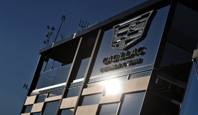 Cadillac Formula Team glass-walled building with the logo reflected and a sun glare.